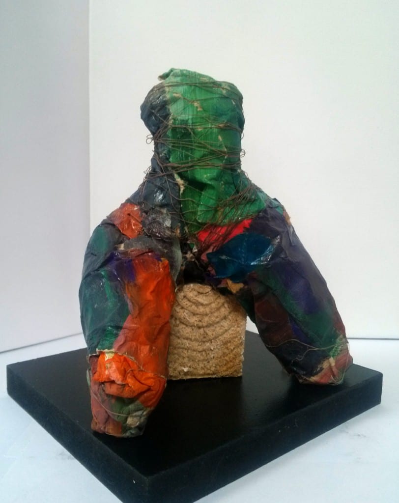 , buste de femme, réalisée en papier exclusivement assis sur un socle en bois Les papiers ont été peints et déchirées puis tordus, collés et parfois emmaillotés de fils de couture.  Le buste composé est assis sur du bois brut et le tout est posé sur un socle bois noir. Cette sculpture " femme bien assise" est là pour résister aux temps présents et demeurer, forte de ses convictions!  